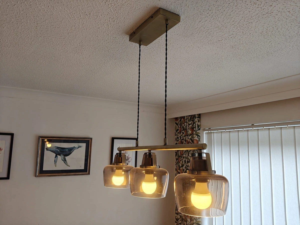 Three light pendant fitted over a dining area