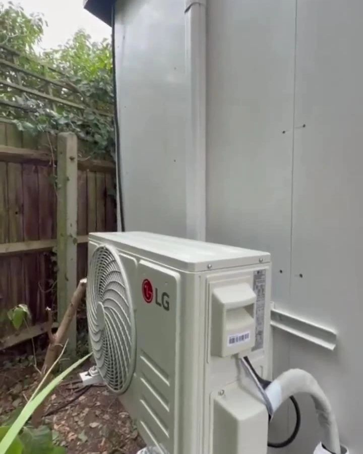 Perennia Climate Services engineer fitting a wall-mounted indoor air conditioning unit during installation