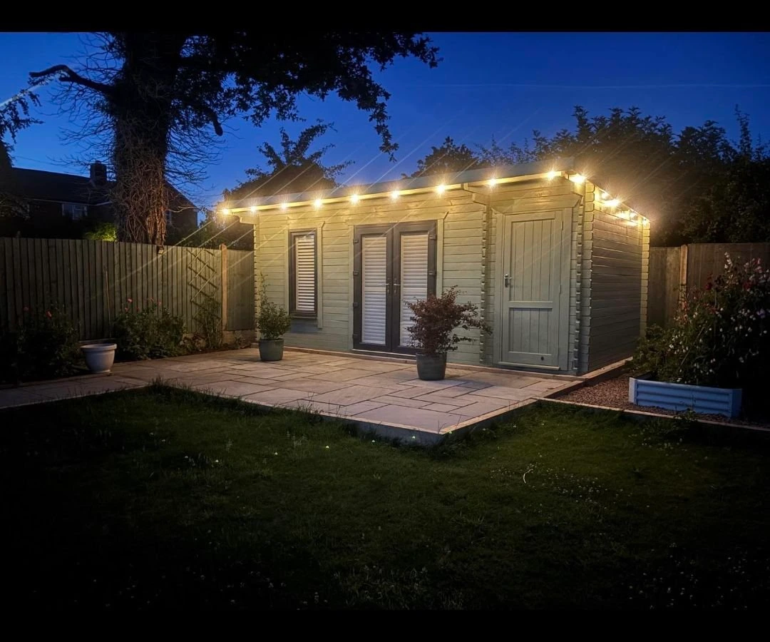 Garden room lit with outdoor festoon lighting at dusk